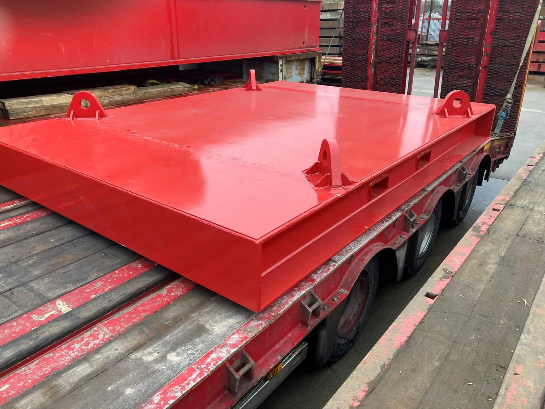 Red M&M test weights platform for industrial lifting and calibration.